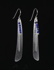 a dangle ear wire featuring a sterling silver blade dusted with diamonds and protected with rhodium.  The blade is topped with silver chain and a strand of faceted lapis lazuli.  The length is approximately 2.5.”