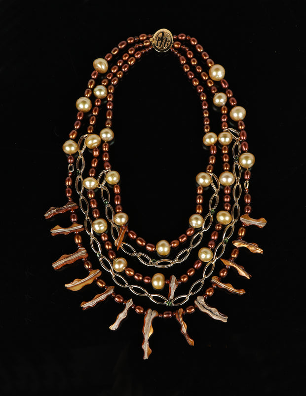 This pearl, spessartite garnet, tourmaline, and gold bib necklace proves it is possible to dress up and down with great jewelry. The longest strand is 22.”