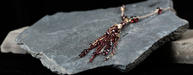 14kt. yellow gold.  A 35" necklace of gold chain and almandine garnet. The necklace ends in a 4” many-strand tassel. 