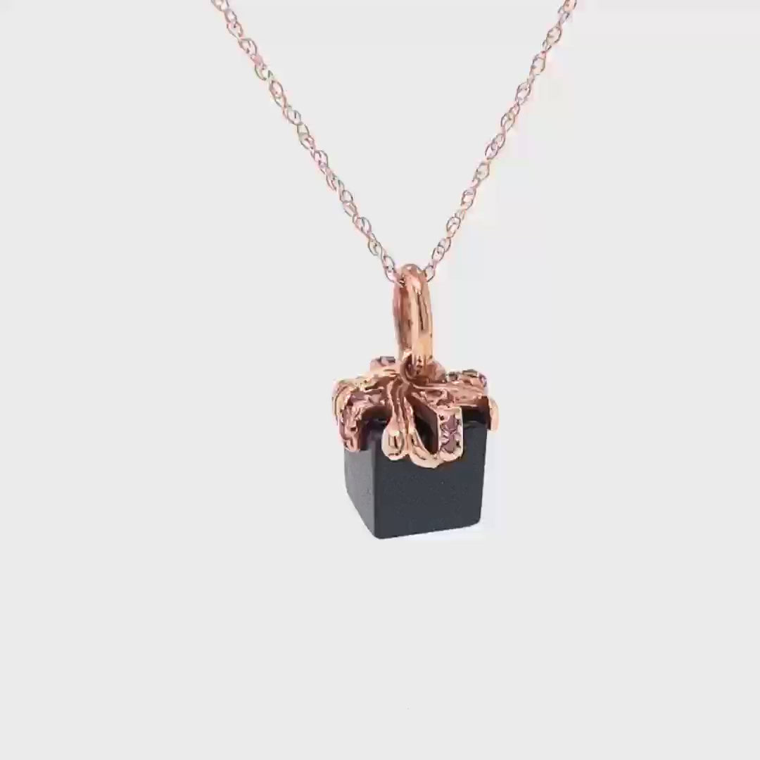 14kt rose gold ribbon, set with 16 rose diamonds (approx .11 cts) on a black spinel cube.