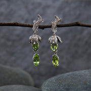 14kt white gold earrings.  Gem: peridot (est total ct wt 4.20).  White Orchid Studio vanilla leaves and bead caps. The approximate length is 1.5."