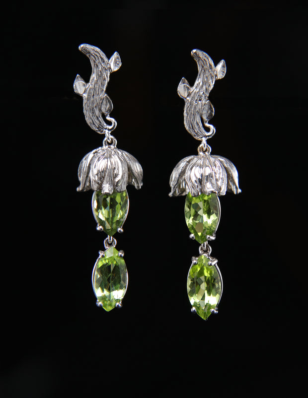 14kt white gold earrings.  Gem: peridot (est total ct wt 4.20).  White Orchid Studio vanilla leaves and bead caps. The approximate length is 1.5."