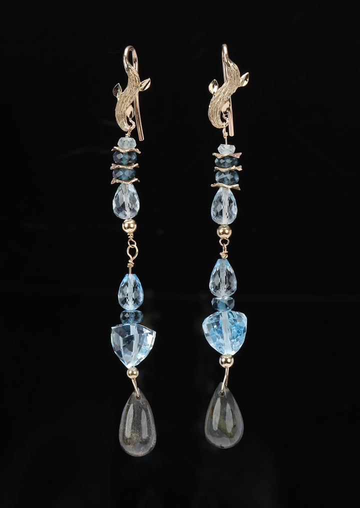 Sky and London blue topaz cascade down to flashing labradorite to create a drop ear wire, approximately 3.25” long.  14kt yellow gold.  White Orchid Studio’s vanilla bean ear wires and spacers.  