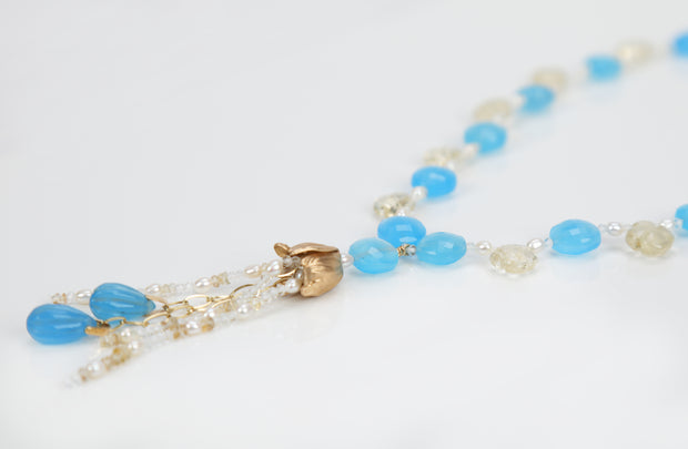 14kt yellow gold choker necklace (16”) with a tassel (3”).  Gems: blue chalcedony, carved scapolite, white topaz, and pearl. 