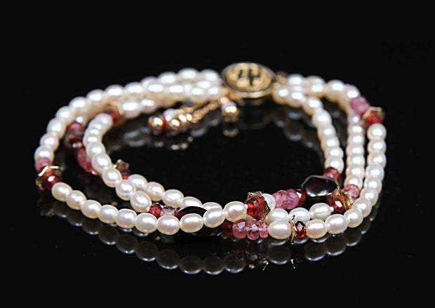 A pearl, pink tourmaline, ruby, garnet, and gold bracelet.  14kt yellow gold. 7.5”