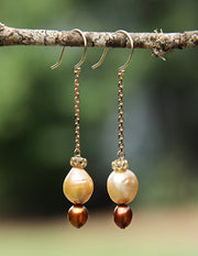 14kt yellow gold crown, chain, and shepherd hooks. Gems: golden and bronze freshwater pearls.  Approximate length is 2.5."