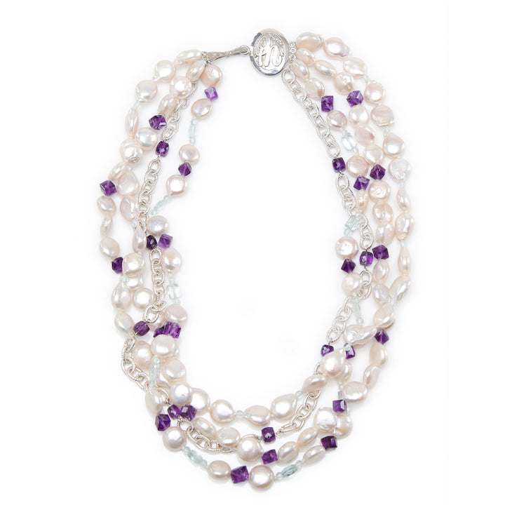 Sterling silver.  Gems: white freshwater pearls, amethyst, and aquamarine.  White Orchid Studio logo clasp.   Four-strand torsade.  Approximate length is 18.”