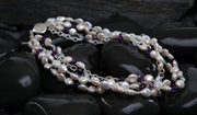 Sterling silver.  Gems: white freshwater pearls, amethyst, and aquamarine.  White Orchid Studio logo clasp.   Four-strand torsade.  Approximate length is 18.”
