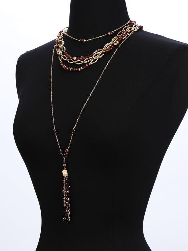 14kt. yellow gold.  This 35" necklace of gold chain and almandine garnet layers beautifully, especially with the 4" tassel..