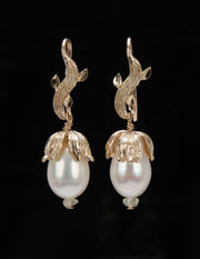 14kt yellow gold.  Gems: white freshwater pearls and Songea sapphires.  White Orchid Studio vanilla leaf ear wire and bead cap.  Approximate length is 1.5.”