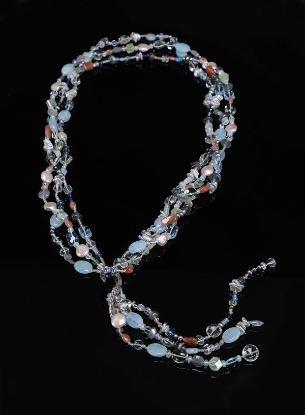 Sterling silver.  Gems: blue topaz, moonstone, aquamarine, pearls, apatite, and sapphires. White Orchid Studio’s vanilla bean lariat set deep blue sapphires. Approximate lengths 26” + 8" for the tassel.