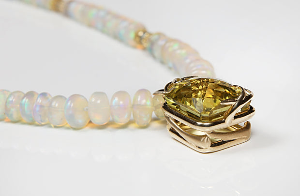 14kt. yellow gold.  Gems: citrine (27.23 cts.), Welo opals and sky blue topaz.  Custom gold basket for the citrine is embellished with a moth orchid and vanilla beans, filigree spacers, and Studio logo clasp.