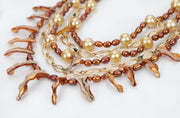 This pearl, spessartite garnet, tourmaline, and gold bib necklace proves it is possible to dress up and down with great jewelry. The longest strand is 22.”
