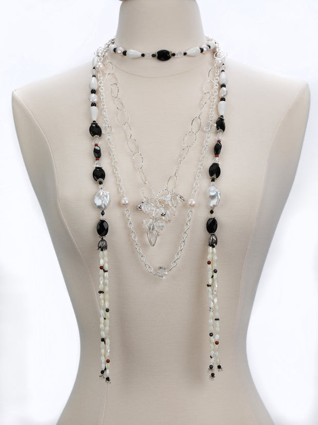 Layering is the rage.  Sterling silver.  Gems: pearl, onyx, agate, quartz, and jasper. White Orchid Studio’s floral bead cap.  Approximate length 56.”