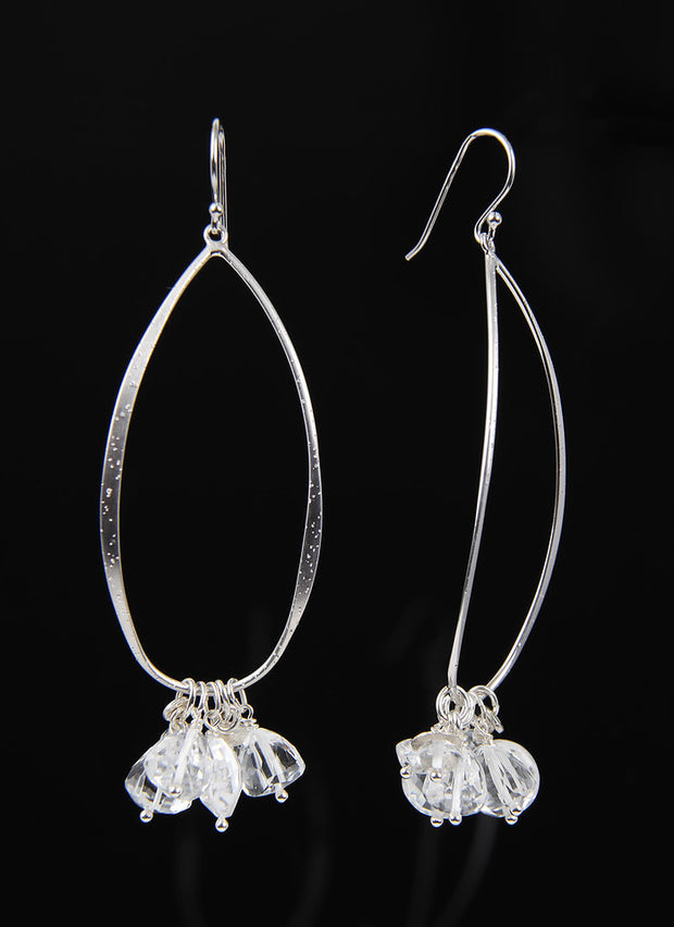 sterling ear wires dusted with diamonds and protected with rhodium. The loop supports sparkling clear quartz of various shapes and sizes. A 3" length.