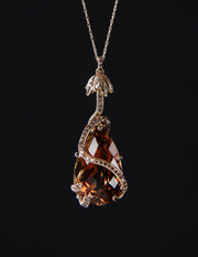 14kt yellow gold pendant featuring a natural precious topaz (29.53 cts.) and 52 Champagne diamonds (.420 cts. t.w.).  Approximate dimensions: 1.5” long x .6” wide.