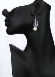 A drop ear wire of beautiful, white freshwater pearls, paired with a faceted, pear shape crystal quartz. A sterling ear wire suspends the gems for an approximate 2" length.